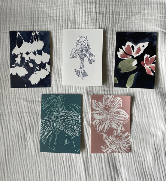 Set of five illustrated greetings cards by Verity Burton featuring floral line and water colour prints. The cards are laid on top of white muslin fabric background.