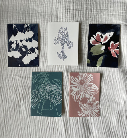 Set of five illustrated greetings cards by Verity Burton featuring floral line and water colour prints. The cards are laid on top of white muslin fabric background.